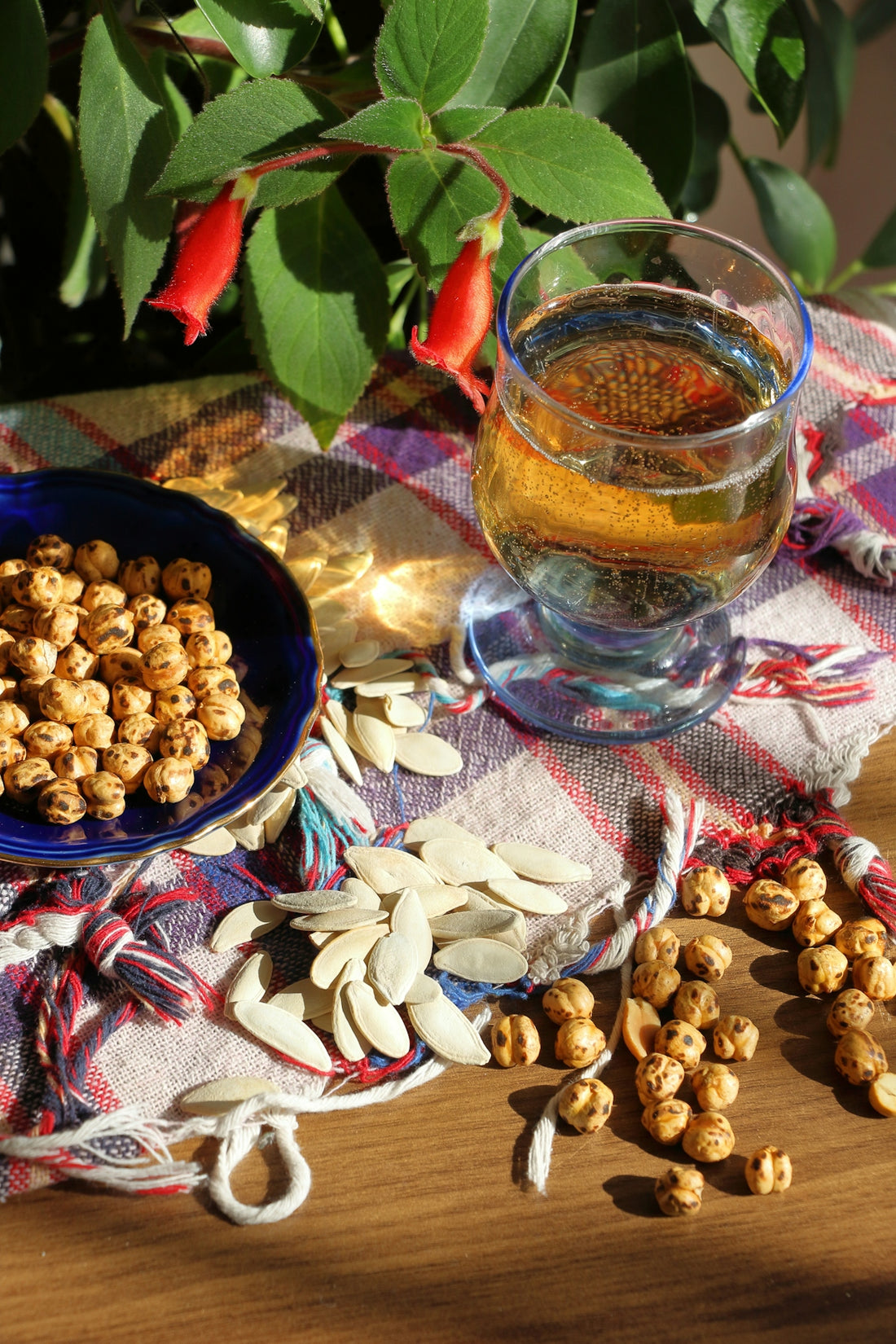 a bowl of nuts next to a glass of tea